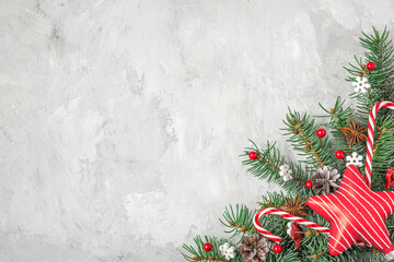 Fototapeta na wymiar Christmas background. Fir tree, festive decorations, red star on gray concrete background. Flat lay. Top view