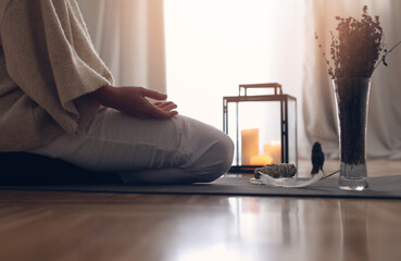 Open Hands Meditation concept. Woman sitting in lotus position , Candle light, Cozy Atmosphere