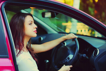 Fototapeta na wymiar Portrait of beautiful young woman driver behind a wheel car