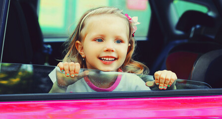 Portrait of happy smiling little child passenger sitting in the car