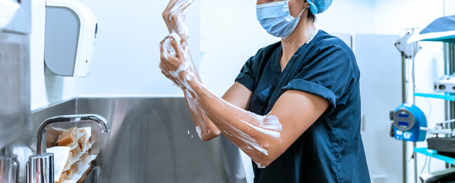 Surgeon having his hands surgically washed. A Caucasian doctor dressed in his right-hand profile with his hands full of foam and dressed in his surgical uniform.
