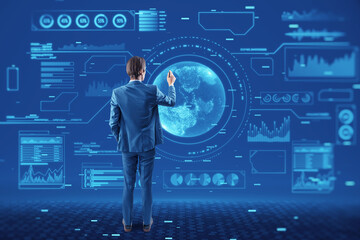 Back view of young european businessman using abstract glowing digital business interface with globe and various other icons. Tech, future and economy concept.