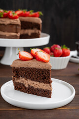 Naked chocolate cake with cream and fresh strawberries on top. Rustic style. Selective focus. Copy space.