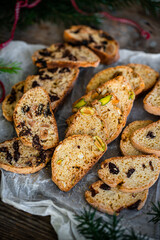 Christmas cookies. Heap of three different kinds of biscotti (chocolate, dried fruits, pistachio) on wooden table.