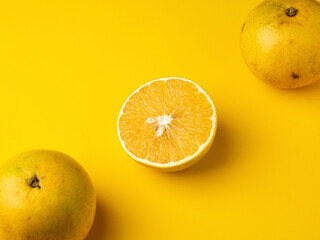 Naranjas sobre una mesa de fondo amarillo.