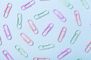 Multiple paperclip, flat lay group of objects on blue background
