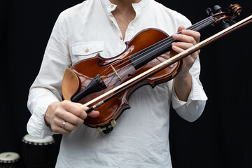A musician with a violin in his hands, an artist before the performance