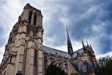 Low angle shot of the Notre Dame Cathedral of Paris under dramaric sunset sky