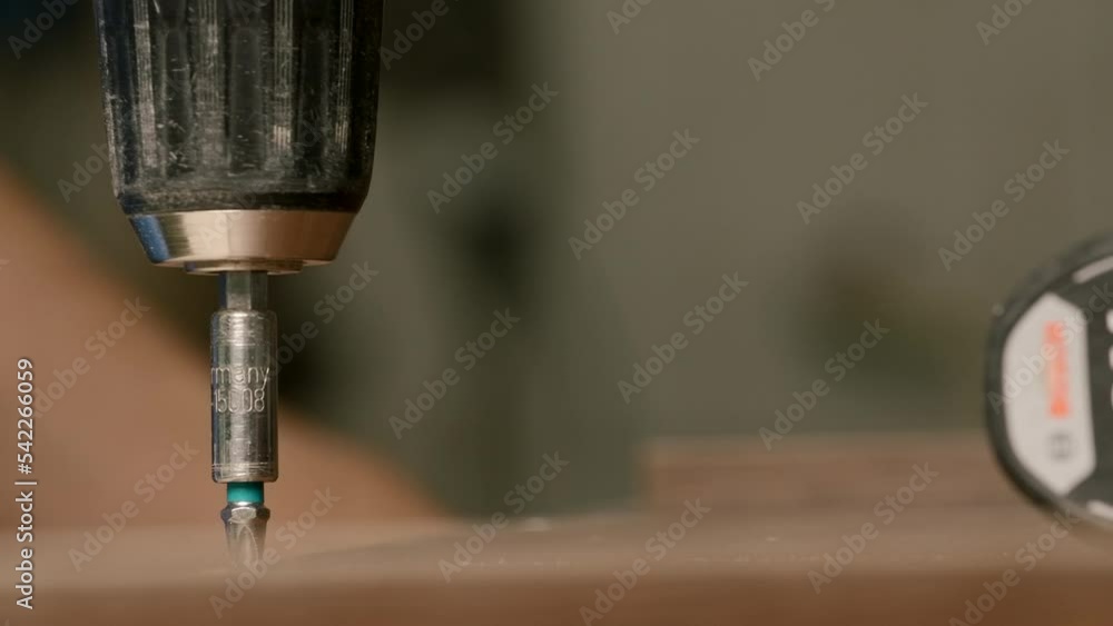 Poster close up of a man carpenter using screwdriver while working with a wooden product. creative. woodwor
