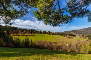 Widok na jesienne doliny w górach. Jesienna panorama z niebieskim niebem i zieloną doliną. Krajobrazy jesienne w Polsce. Ujęcie plenerowe.	