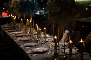 Luxury elegant table setting dinner with candles and light bulbs in a restaurant