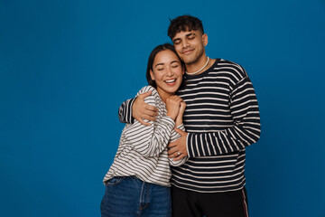 Naklejka premium Young multiracial couple hugging while smiling together