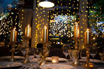 Luxury elegant table setting dinner with candles and light bulbs in a restaurant
