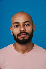 Black bald man with beard posing and looking at camera