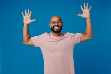 Black bald man with beard smiling and gesturing at camera