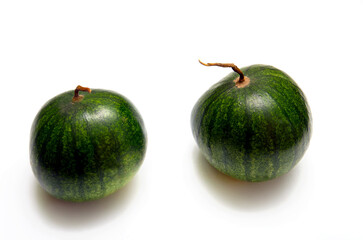 two small watermelons on a light background, watermelons