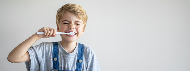 Cute child brush teeth toothbrush, smiling over white background. Studio shot. Dental hygiene,...