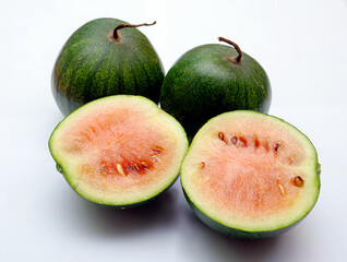 small whole watermelons and halves of watermelons on a light background, watermelons