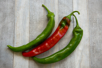 Hot chili pepper background. Red and green peppercorns on a gray wooden table background. Healthy food concept.