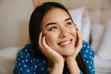Portrait of young beautiful smiling asian woman propping her head
