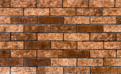 Stylish brick wall with various brown bricks. Brown brick background.