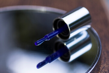 Brush with blue nail polish on mirror