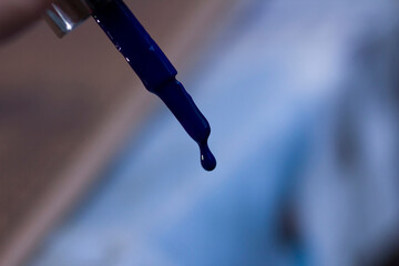 A drop of blue lacquer on a brush close-up
