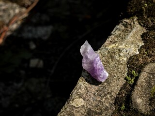 Top view of a beautiful purple precious amethyst on the rock under the sunlight