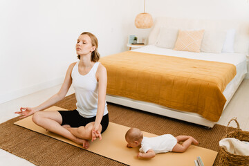 White blonde woman meditating while spending time with her baby