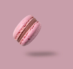 Fly french pink macaroon on a pink background. Concept levitation food.