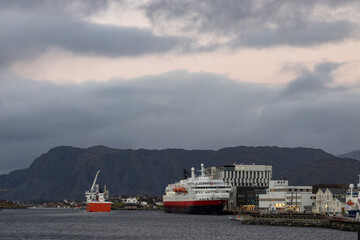 The coastal route Ms Nordlys and With Frohavet in Brønnøysund harbor on the south bound, after sunset, dark and cloudy weather.Norway, Europe