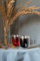 double glass mug, double bottom, with coffee and tea on a background of spikelets