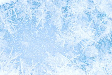 Snow-covered frost pattern on blue ice with a beautiful pattern. Background. Selective focus