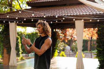 Young ginger man using mobile phone during yoga practice