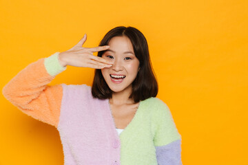 Asian young woman wearing sweater laughing while gesturing