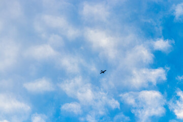 Flugzeug in der Luft mit blauem Himmel und weissen Wolken