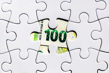 Money found in a missing piece of a jigsaw puzzle. 100 euros found by solving the financial...