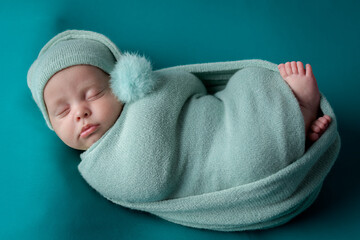 Cute newborn baby with tassel cap wrapped