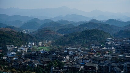 Fototapeta na wymiar Village in Guiyang China with hill forests and haze in the background