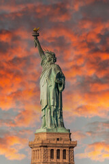 Statue of Liberty against a fiery dramatic sky with clouds