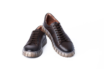 Dark brown leather men's sports-style half-boots with thick fluted soles with lacing on a white background.