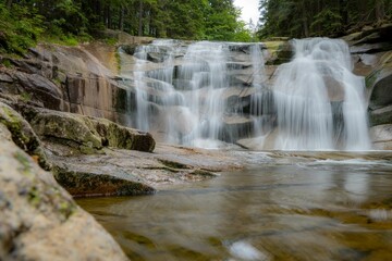 Closeup shot of a beautiful waterfall flowing in the forest