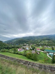 a small village in the mountains. Forest, rocks, clouds. Beautiful landscape, Europe. Traditional wooden houses and a railway