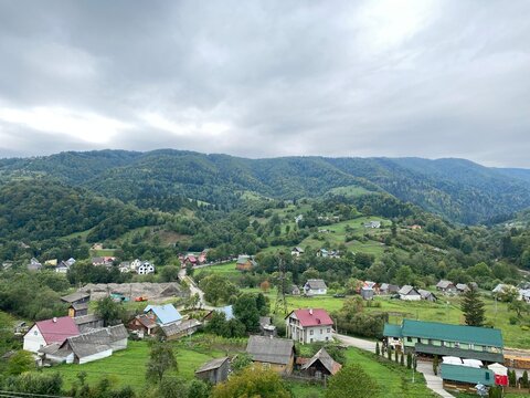 a small village in the mountains. Forest, rocks, clouds. Beautiful landscape, Europe. Traditional wooden houses and a railway