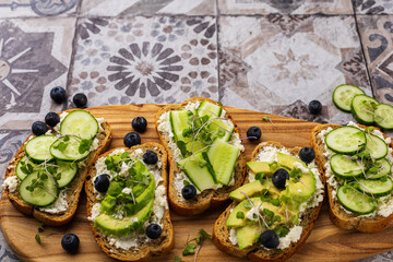 Vegetarian sandwich with microgreens on a wooden board, beautiful serving on a bright background