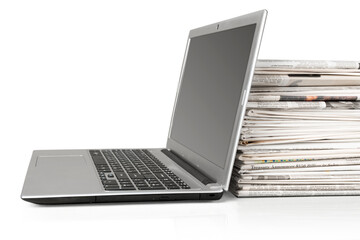 Stack of Newspapers and Laptop