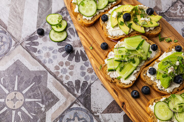 Fototapeta na wymiar Vegetarian sandwich with microgreens on a wooden board, beautiful serving on a bright background