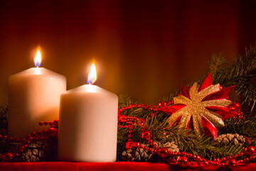Christmas candles and ornaments over dark background with lights