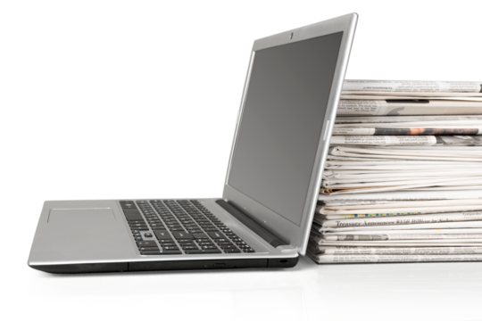 Stack of Newspapers and Laptop