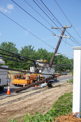 Electric utility repair crew on the scene of a broken wooden utility pole